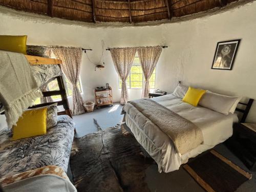 a bedroom with two beds and two windows at Khululeka’s Bush Hut in Millvale
