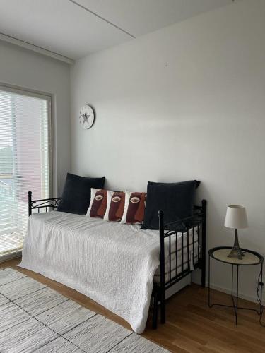 een slaapkamer met een bed met kussens en een klok aan de muur bij Modern apartment nearby Airport 2 in Vantaa