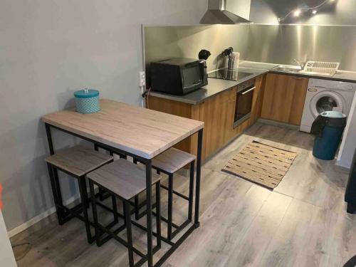 uma pequena cozinha com uma mesa e um micro-ondas em Appartement avec plage et parking em Pietranera