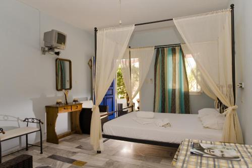 a bedroom with a bed with a canopy at Studio Filoxenia in Lipsoi