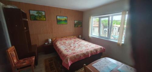 a small bedroom with a bed and a window at Стая за гости "Ирина" in Balchik