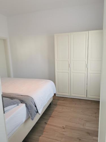 um quarto com armários brancos e piso em madeira em Nr 1 Ferienwohnung am Teutoburger Wald 