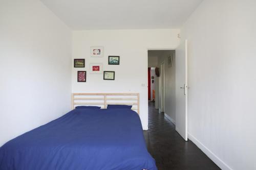 - une chambre avec un lit bleu et un couloir dans l'établissement Espace Lumineux avec Jardin et Garage clos à 15 min de Paris, à Créteil