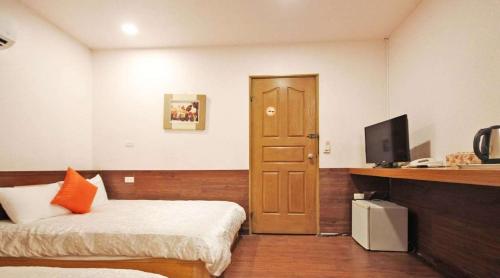 a bedroom with a bed and a desk with a television at 日月潭 -日月住館 in Yuchi