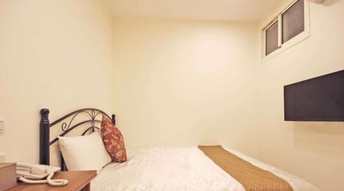 a bedroom with a bed with a phone on a desk at 日月潭 -日月住館 in Yuchi