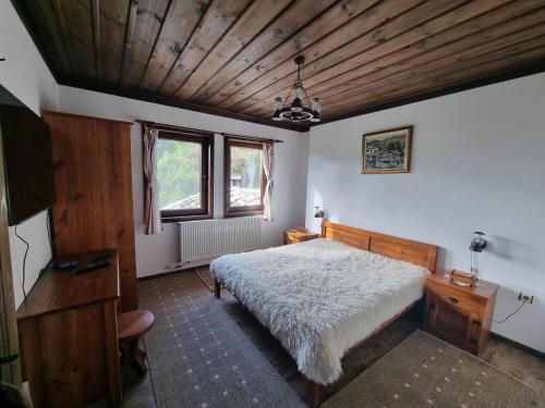 1 dormitorio con cama y techo de madera en Leshten Valentin's House, en Leshten