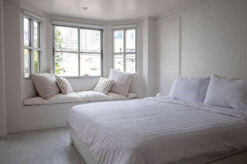1 dormitorio blanco con 1 cama grande y ventanas en Room 4 Bangkok Center WIFI Netflix, en Bangkok