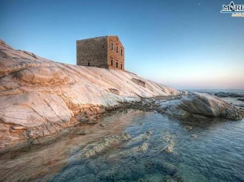 a building on top of a mountain next to the ocean at Sicilia bedda in Agrigento