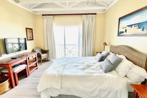 sypialnia z dużym białym łóżkiem i biurkiem w obiekcie Luxury Lodge at Pinnacle Point w mieście Mossel Bay