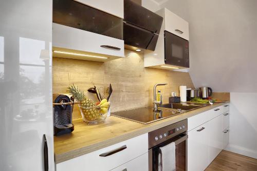 a kitchen with white cabinets and a stainless steel sink at Ostseerauschen in Zingst