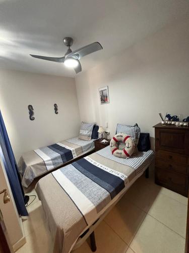 2 camas num quarto com uma ventoinha de tecto em Casa Gloria em Los Abrigos