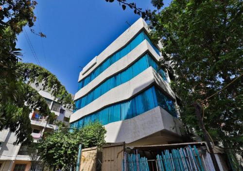 a tall building with blue windows on the side of it at The Sky Imperial Hotel Yahvi in Vadodara