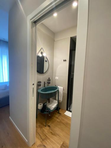uma casa de banho com um lavatório verde e um espelho em Nonno Nicola Rooms em Bari