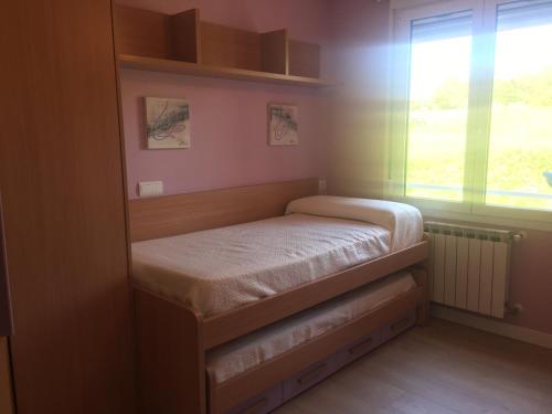 een kleine slaapkamer met een bed en een raam bij paseo de la Quinta in Colindres