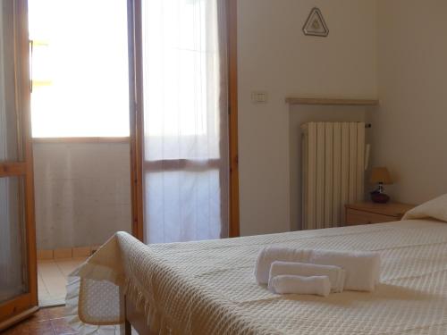 una camera da letto con un letto e due asciugamani di Villetta Puccini a Lido Adriano a Ravenna