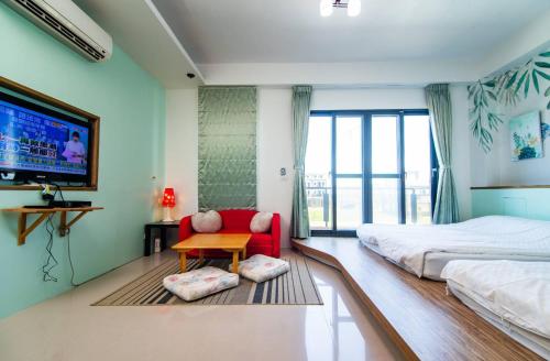 頭城的住宿－閑閑的海，一间卧室配有一张床、一张红色椅子和一台电视。