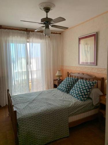 une chambre avec un lit avec un ventilateur de plafond dans l'établissement Appartement au calme proche du centre-ville, à Sanary-sur-Mer