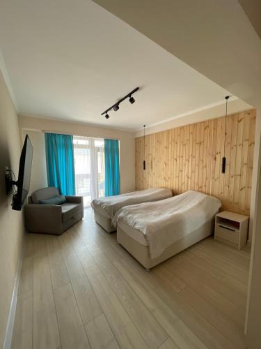 a large bedroom with two beds and a chair at Baytur Trea in Bosteri