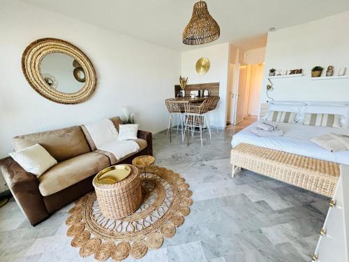 a living room with a couch and a bed at Studio chic et cosy vue mer in La Grande-Motte