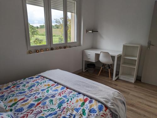 Schlafzimmer mit einem Bett, einem Schreibtisch und einem Fenster in der Unterkunft La Fontaine in Montgaillard-Lauragais