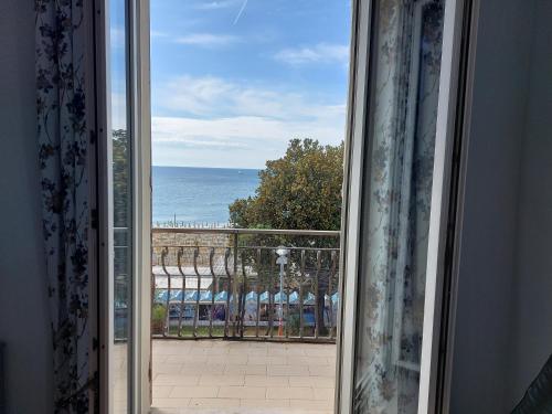 uma janela aberta com vista para o oceano em Casa Ortensia em Albissola Marina