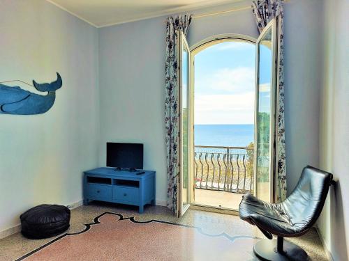 uma sala de estar com uma janela com vista para o oceano em Casa Ortensia em Albissola Marina