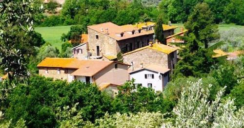 a large house on top of a hill with trees at CasaVacanza Borgo Cenaioli tra Toscana e Umbria Lago Trasimeno in Sant Arcangelo