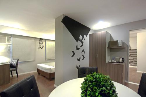 a room with a table and chairs and a bedroom at Astoria Greenbelt in Manila