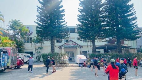 a group of people walking in front of a building at Hung Vuong Hotel in Pleiku