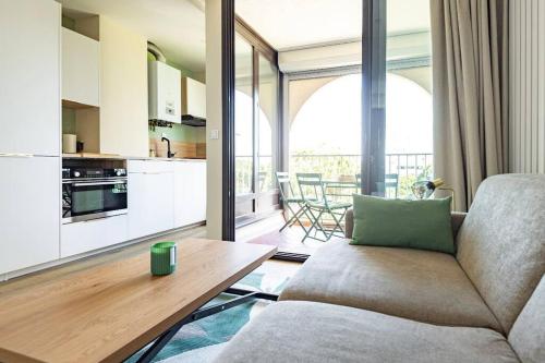 een woonkamer met een bank en een tafel bij Séjour de rêve à La Grande Motte T2 entièrement neuf, clim, wifi, parking privé in La Grande-Motte