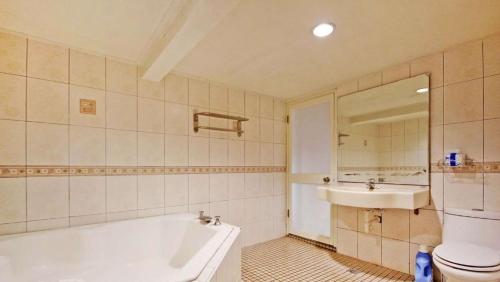 a bathroom with a tub and a toilet and a sink at 日月潭 -日月住館 in Yuchi