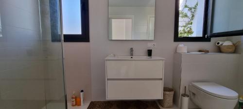 a bathroom with a toilet and a sink and a shower at Casa Blanca in L'Escala