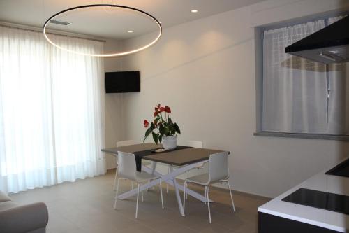 a dining room with a table and white chairs at Hotel Il Grappolo D'Oro in Monforte dʼAlba