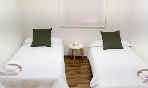 two beds sitting next to each other in a room at Slappe Jaén II in Jaén
