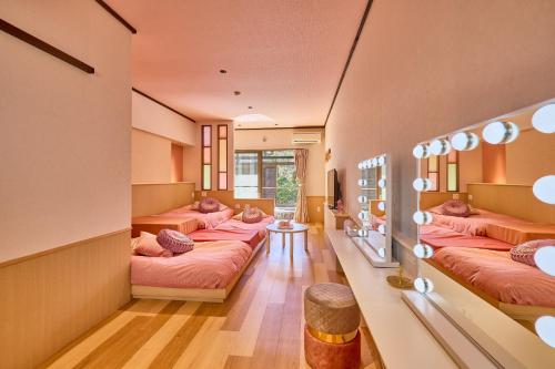 um quarto com quatro camas e uma mesa em Sengokuhara Shinanoki Ichinoyu em Hakone