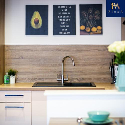 a kitchen with a sink and some pictures on the wall at Pluxa Mint Bliss - Stylish with workspace in Birmingham
