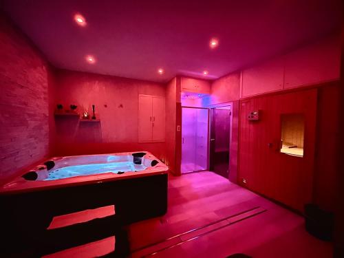 Habitación rosa con baño con bañera de hidromasaje. en Magic Hotel, en Atena Lucana