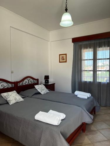 a bedroom with two beds with towels on them at Anemos Apartments in Marathokampos