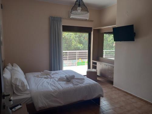 um quarto com uma cama e uma grande janela em Giannis Villa em Skinés