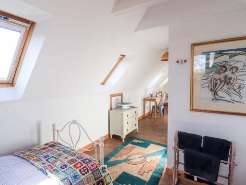 a bedroom with a bed and a painting on the wall at Brodie East Cottage in Forres