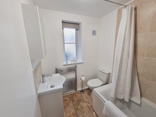 Baño blanco con lavabo y aseo en FW Haute Apartments at Harwoods Road, Multiple 2 Bedroom Pet Friendly Flats, King or Twin or Double beds with FREE WIFI and FREE PARKING, en Watford