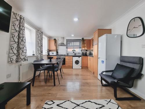 a kitchen with a table and chairs and a refrigerator at Aisiki Stays Apartments at Harwoods Road, Multiple 2-Bedroom, Pet-Friendly Flat, King or Twin or Double Beds, with Free Wi-Fi and Parking Space in Watford