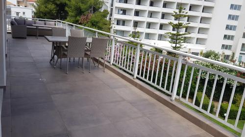 a balcony with a table and chairs and a building at Luxury penthouse with sea view in Hanioti