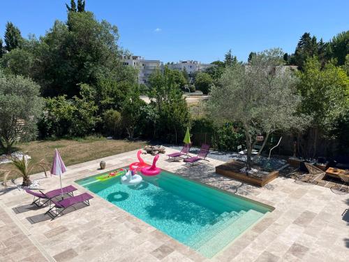 a swimming pool with a pink inflatablevisor in a backyard at Location saisonnière 1 in Clermont-lʼHérault