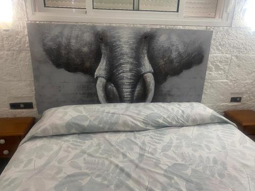 uma pintura de um elefante na cabeça de uma cama em Tossa de mar Amplio Apartamento con vistas al mar em Tossa de Mar