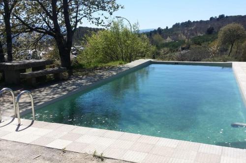 ein großer Pool mit einer Bank daneben in der Unterkunft Casiña do Cereixeiro Roblido in Roblido