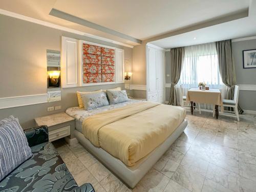 a bedroom with a large bed and a desk at At Pingnakorn Nimman Hotel in Chiang Mai