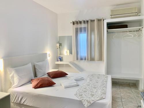 a white bed with two pillows in a bedroom at Anemos Studios in Adamas