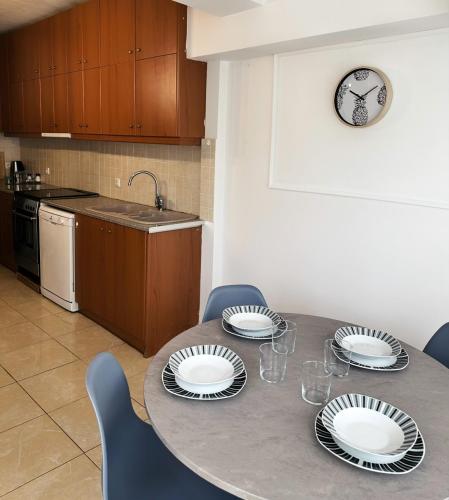 a kitchen with a table with plates on it at Kallikratis Apartment Near Athens Airport in Spáta