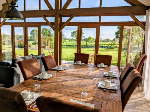a large wooden table in a room with a large window at Chambres d'hôtes chez l'habitant - Bed & Breakfast homestay in Huisnes-sur-Mer